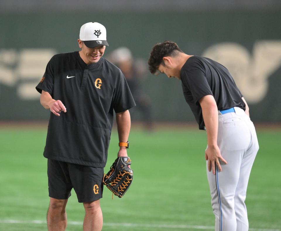 　試合前、斎藤（右）からあいさつされる阿部監督（撮影・伊藤笙子）