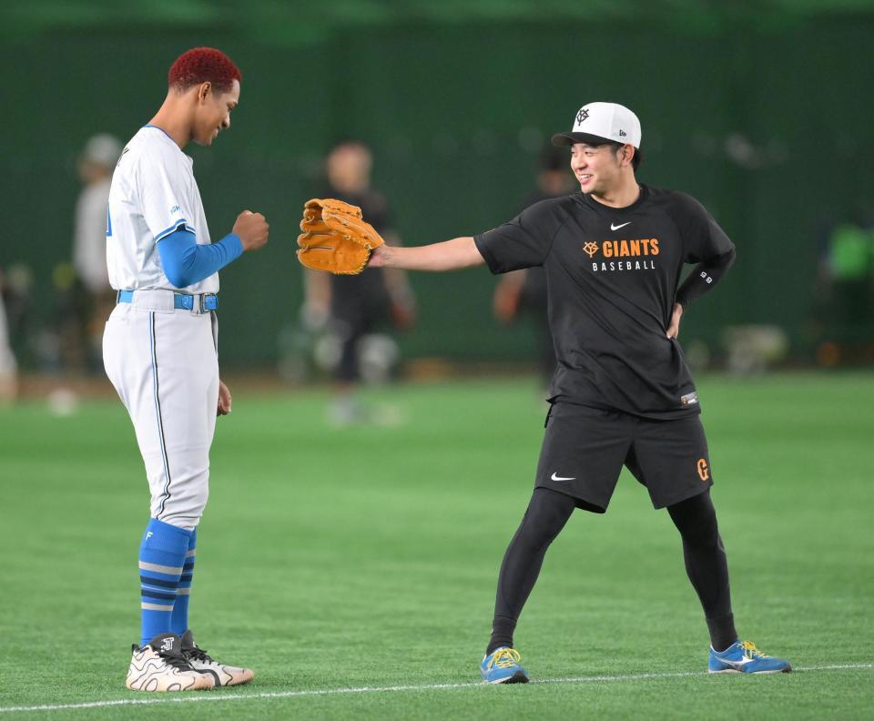 　試合前、グータッチする万波（左）と石川（撮影・伊藤笙子）