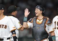 　西武に勝利し、笑顔で阿部監督（左）とタッチを交わす小林（撮影・西岡正）