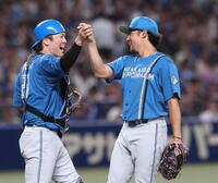　伏見（左）とタッチをする完封で７勝目を挙げた伊藤（撮影・佐々木彰尚）