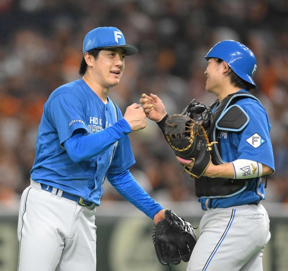 　ノーヒットノーランを逃したものの完投勝利を挙げ、田宮（右）とタッチを交わす北山（撮影・伊藤笙子）