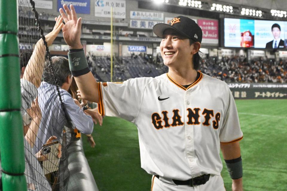 　場内を１周し、観客と笑顔でタッチを交わす小林