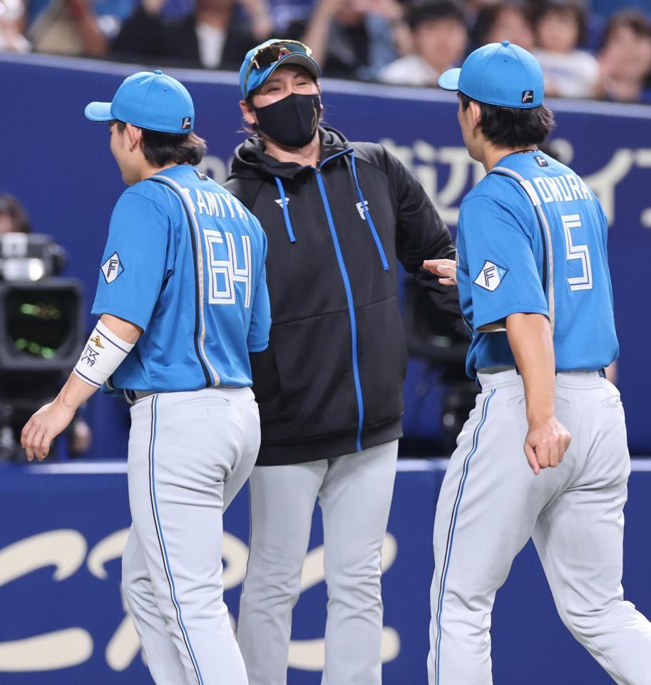 　中日に勝利し、ナインとタッチを交わす新庄監督（中）