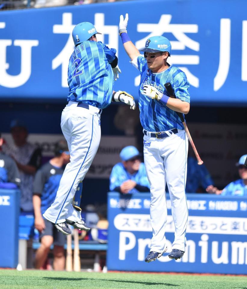 　２回、先制の左越えソロを放った牧（左）とジャンピングタッチをかわす筒香（撮影・開出牧）