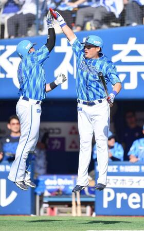 　６回、１３号ソロを放った牧（左）とジャンピングタッチを交わす筒香（撮影・開出牧）