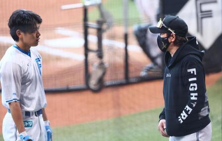 　野村（左）にアドバイスをする新庄監督（撮影・中島達哉）