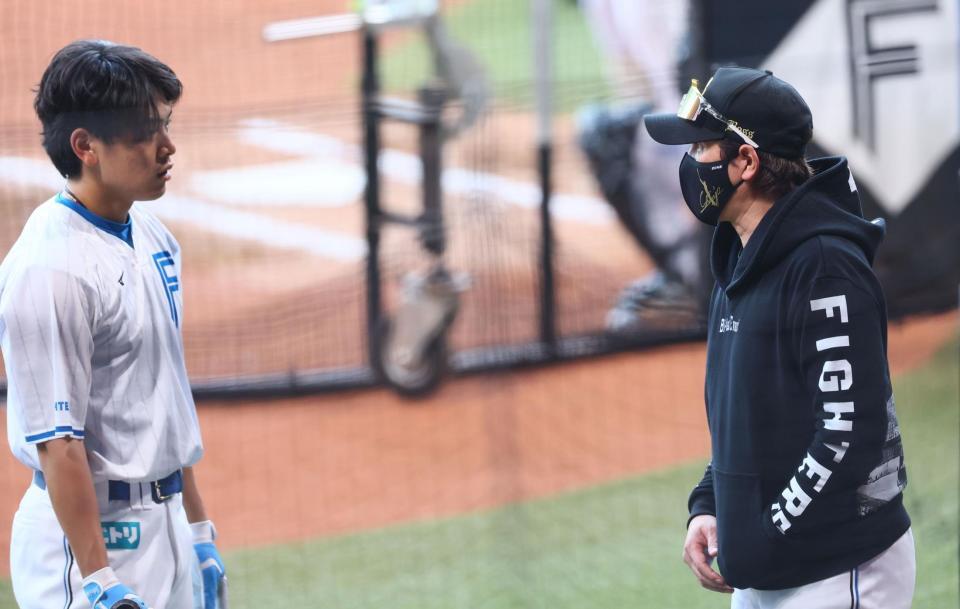 　野村（左）にアドバイスをする新庄監督（撮影・中島達哉）