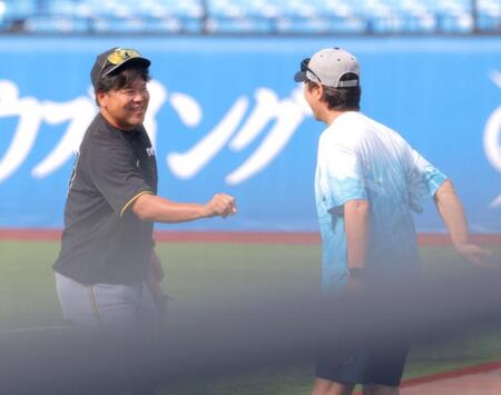 　グータッチを求めるも、高津監督（右）にかわされ，笑い出す野村コーチ（撮影・西岡正）