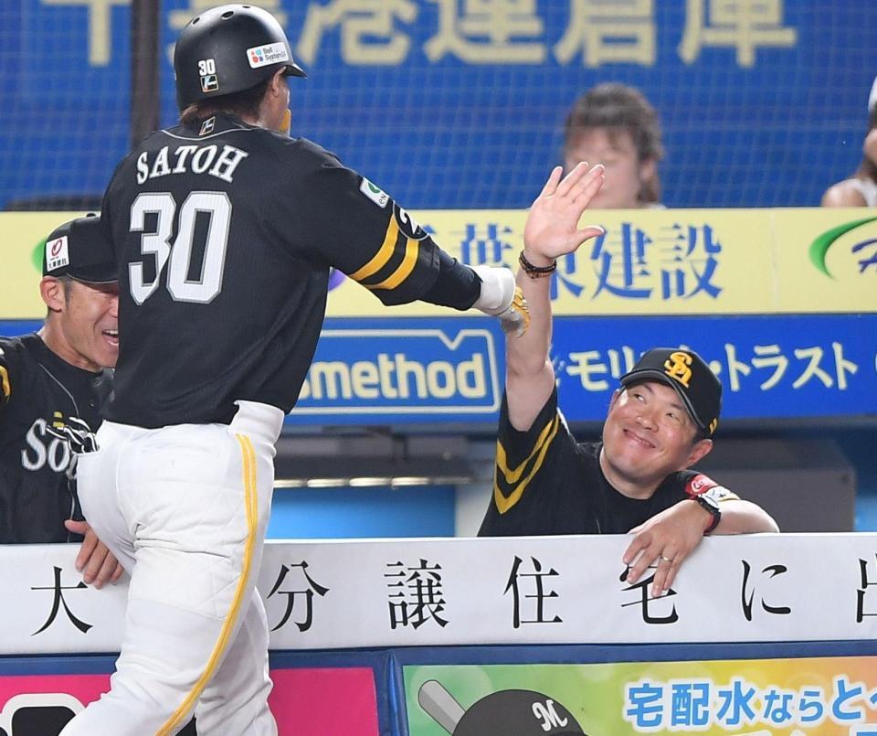 　６回、同点の左越えソロを放った佐藤直（左）とタッチを交わす小久保監督（撮影・開出牧）
