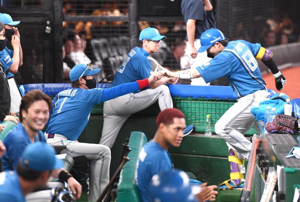 　４回、反撃の一発を放った田宮（右）とベンチで指タッチをする新庄監督（撮影・園田高夫）