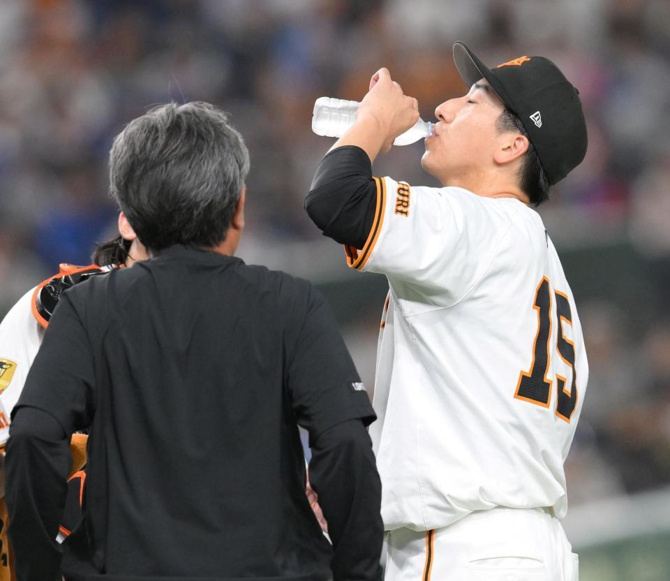 　８回、佐野の打席中に杉内コーチから受け取った水を飲む大勢（撮影・伊藤笙子）