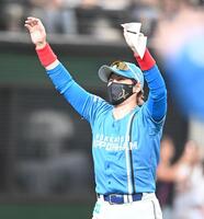 　スタメン表を交換しファンに向かって手を振る新庄監督（撮影・園田高夫）