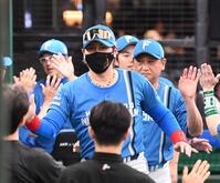 　会心の勝利を挙げコーチ陣とタッチして喜ぶ新庄監督（撮影・園田高夫）