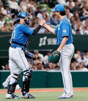 　プロ初完投で５勝目を挙げ、伏見とタッチを交わす達