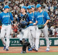 　プロ初完投で５勝目を挙げ、ウイニングボールを手に笑顔の達（右端）