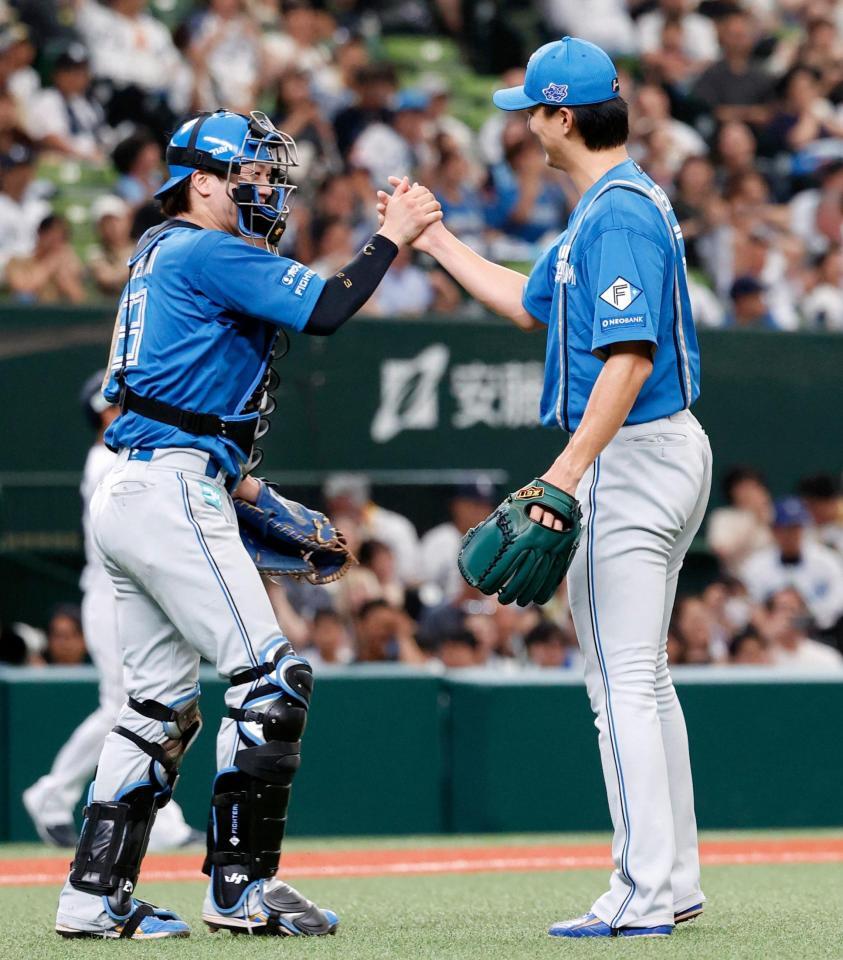 　プロ初完投で５勝目を挙げ、伏見とタッチを交わす達