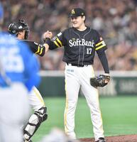 　完封で今季５勝目を挙げ海野（左）と握手を交わす有原（撮影・開出牧）