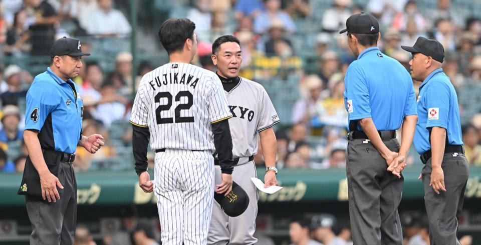 　メンバー表の交換時に、審判団らに一言話す阿部監督（中央）＝撮影・西田忠信