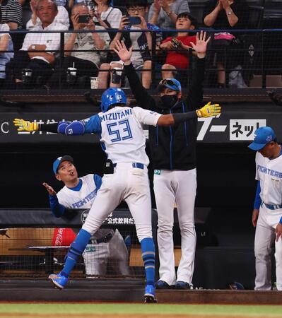 　７回、ソロを放った水谷（５３）をハイタッチで迎える新庄監督（右から２人目）＝撮影・中島達哉