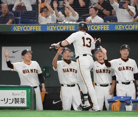 　８回、先制の右越えソロを放った代打・キャベッジ（１３）とタッチを交わす阿部監督（左から２人目）＝撮影・開出牧