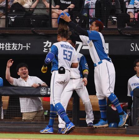 　７回、ソロを放った水谷（中央）のヘルメットを取る万波（右）＝撮影・中島達哉