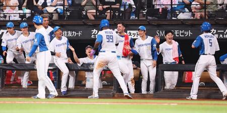 　３回、水野の適時二塁打で生還したレイエス（中央）、野村（右）を迎える日本ハムナイン（撮影・中島達哉）