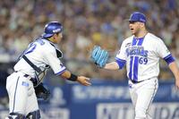 　７回を無失点に抑え、山本（左）とタッチを交わすケイ（撮影・西岡正）