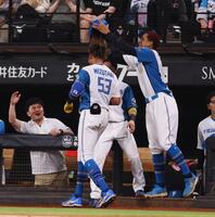 　７回、ソロを放った水谷（中央）のヘルメットを取る万波（右）＝撮影・中島達哉