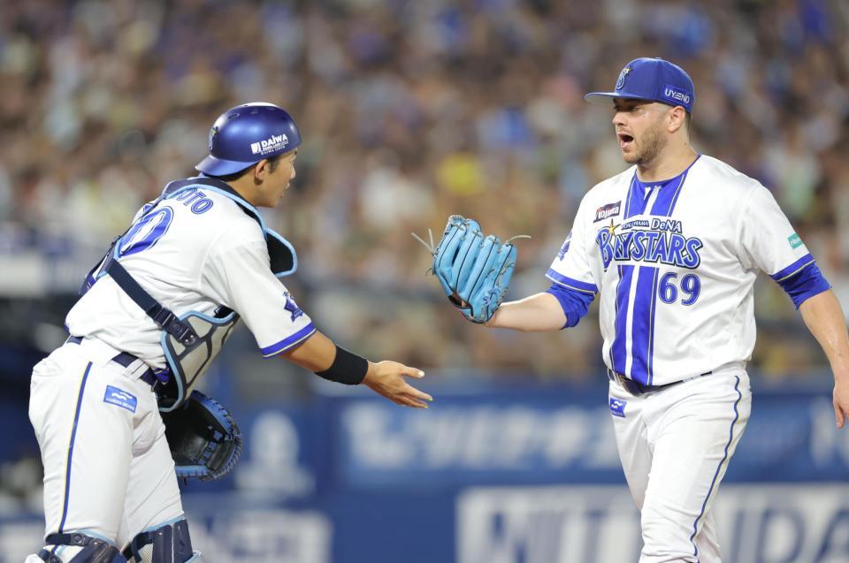 　７回を無失点に抑え、山本（左）とタッチを交わすケイ（撮影・西岡正）