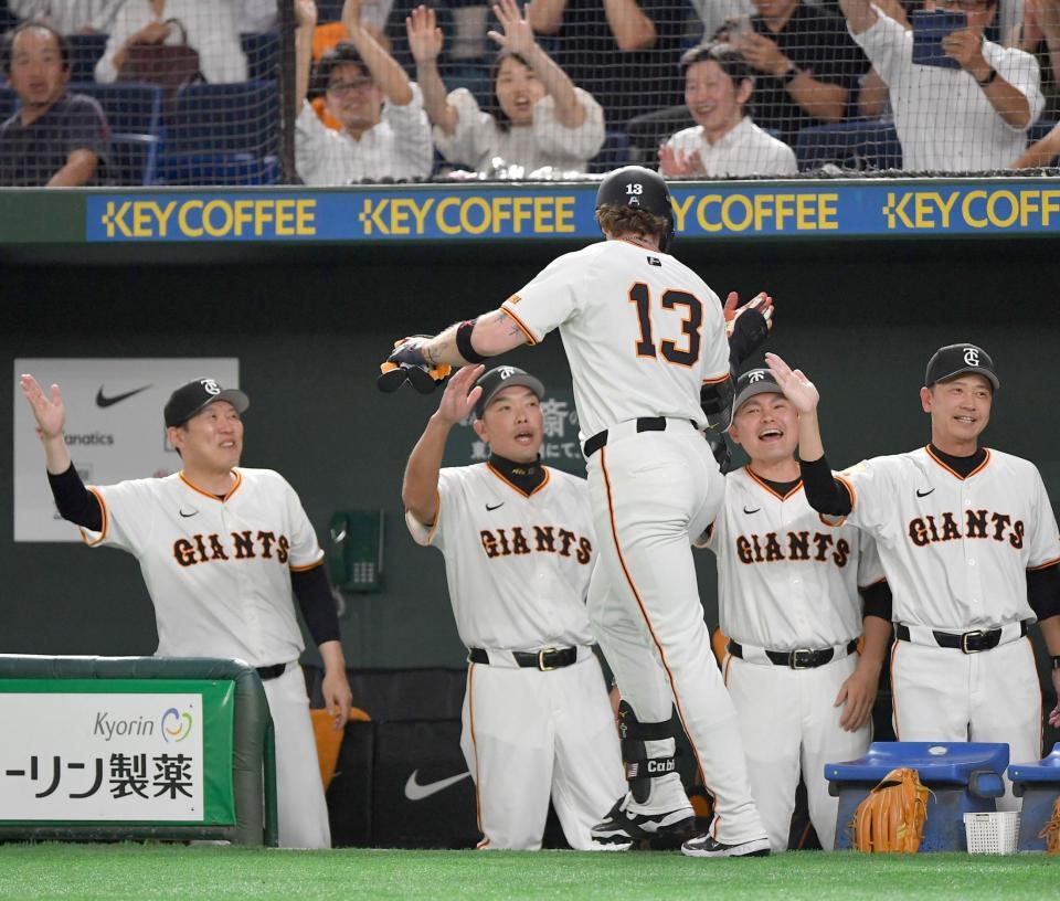 　８回、先制の右越えソロを放った代打・キャベッジ（１３）とタッチを交わす阿部監督（左から２人目）＝撮影・開出牧