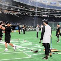 　スイングを実演する阿部監督（左）。右は泉口