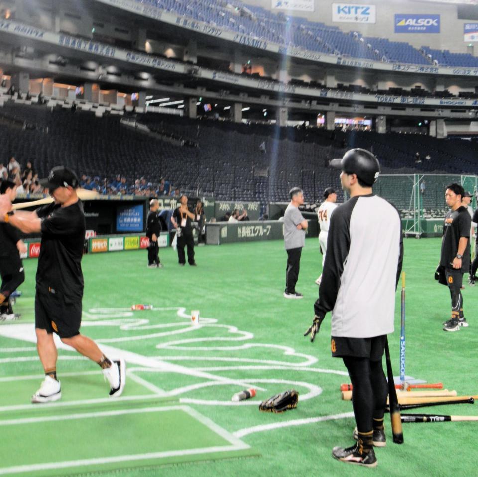 　スイングを実演する阿部監督（左）。右は泉口