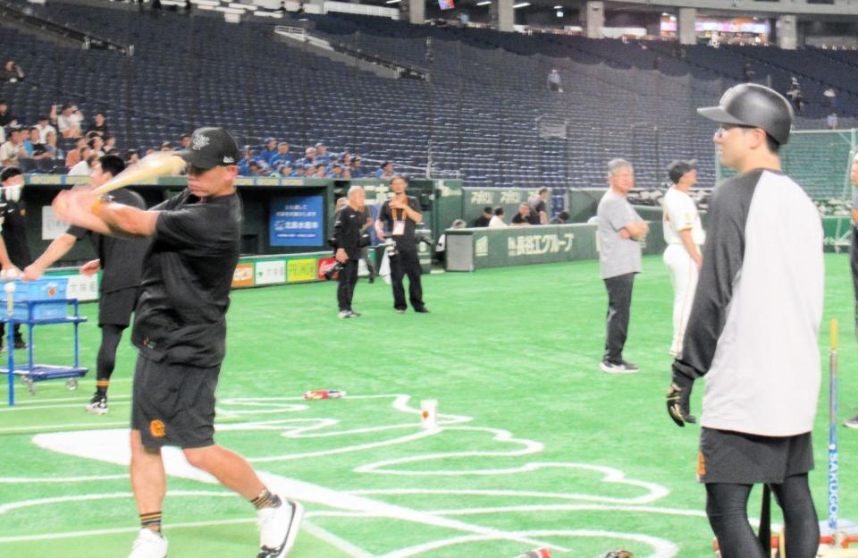 　スイングを実演する阿部監督。右は泉口