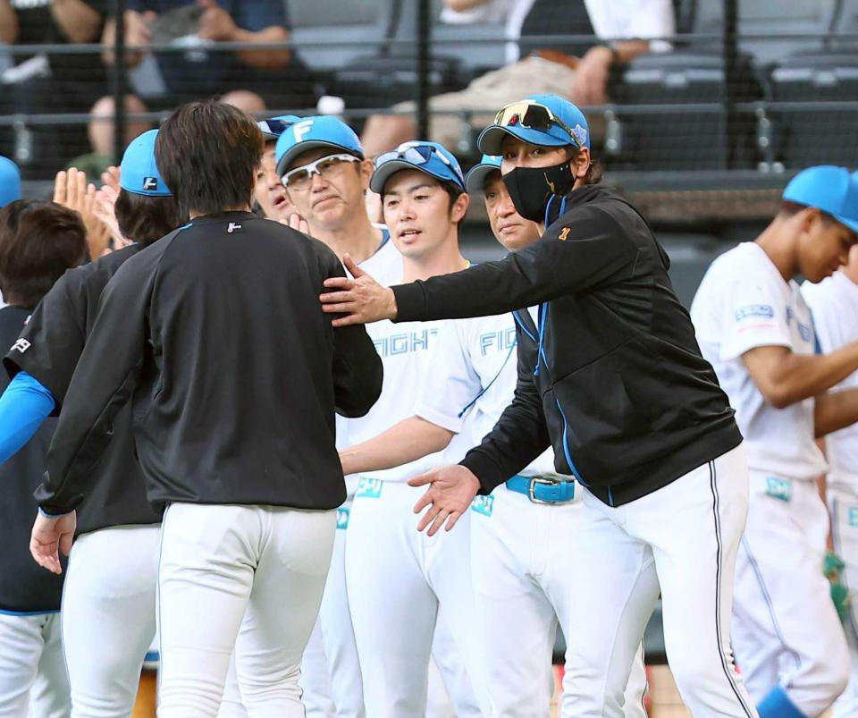 　勝利後にナインを迎える新庄監督（右）