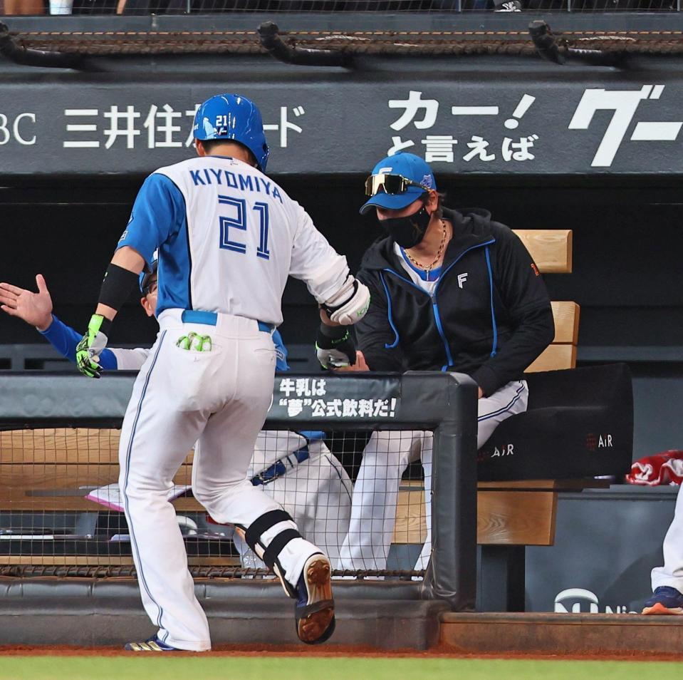 　７回、勝ち越し２ランを放った清宮幸（左）を指先タッチで迎える新庄監督（撮影・中島達哉）