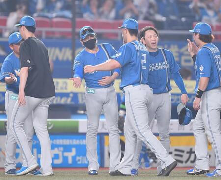　延長戦でロッテに競り勝ちマルティネス（２）らナインとタッチを交わす新庄監督（左から３人目）＝撮影・開出牧