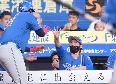 　１回、先制の右越え満塁ホームランを放ったレイエス（左）を迎える新庄監督（撮影・開出牧）