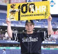 　通算１００号を達成し、記念ボードを掲げる近藤（撮影・立川洋一郎）