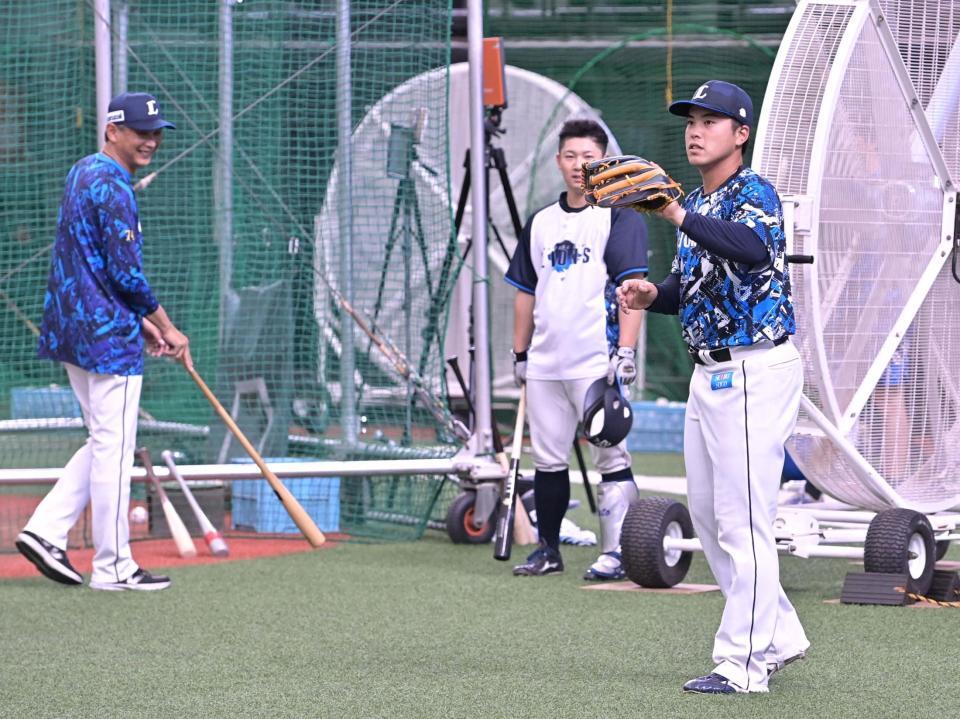 　支配下登録され１軍の練習に参加する仲三河（右）と西口監督（左）＝撮影・持木克友