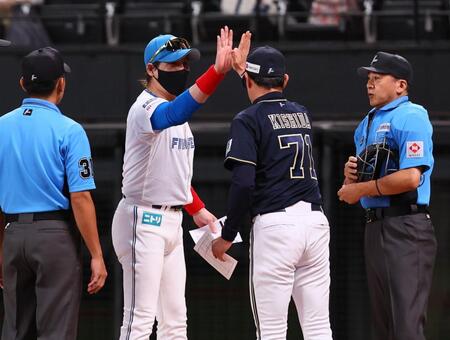 　メンバー表を交換し、岸田監督（右から２人目）とハイタッチを交わす新庄監督（中央左）＝撮影・中島達哉