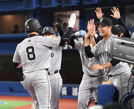 　８回、丸（左）は同点適時二塁打を放ち、ナインに迎えられる（撮影・佐藤厚）