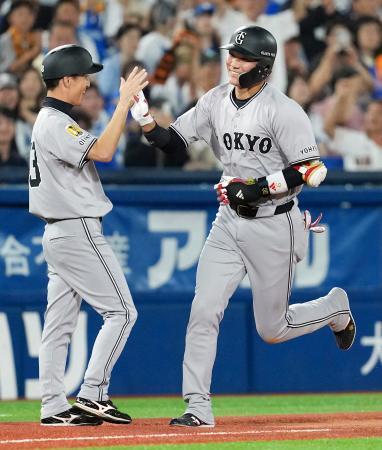　１１回、勝ち越しソロを放ち、コーチとタッチを交わす巨人・坂本（右）＝横浜