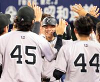 　１１回、勝ち越しソロを放ち、ナインに迎えられる坂本