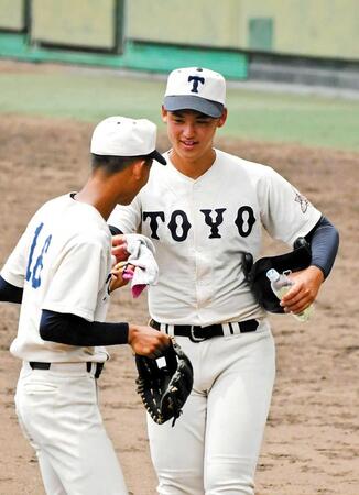 　イニングの合間、守備に向かうチームメートに用具を手渡す阪下（右）