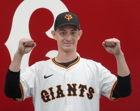 　入団記者会見でガッツポーズする巨人の乙坂＝１３日、川崎市のジャイアンツ球場