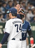 　メンバー表交換でハイタッチする新庄監督（奥）と西口監督