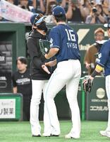　完投勝利の達とタッチを交わす新庄監督