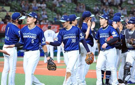 　西武に勝利し、タッチを交わす石井（中央）ら。左端は新庄監督