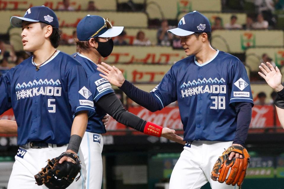 　試合終了後、新庄監督（中央）に迎えられる石井