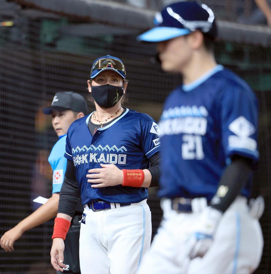 　８回表を終え、選手交代を告げた新庄監督。手前は空振り三振に倒れた清宮幸